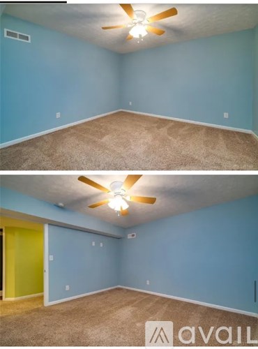 A room with a ceiling fan and carpeted floor.