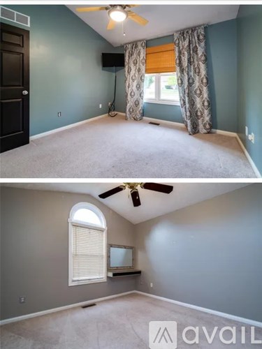 A room with a ceiling fan and a window with curtains.