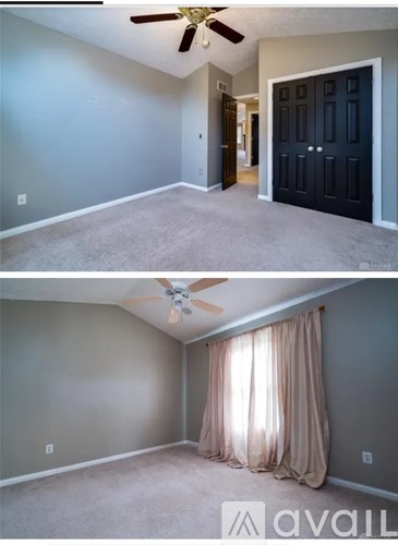 A room with a ceiling fan and a door.