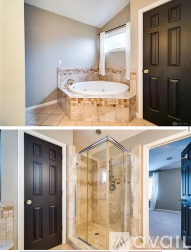 A bathroom with a black door and a glass shower stall.
