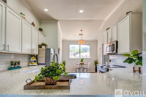 A kitchen with a large island and a dining table.