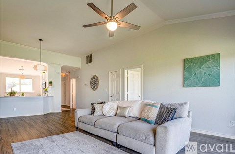 A living room with a couch and a ceiling fan.
