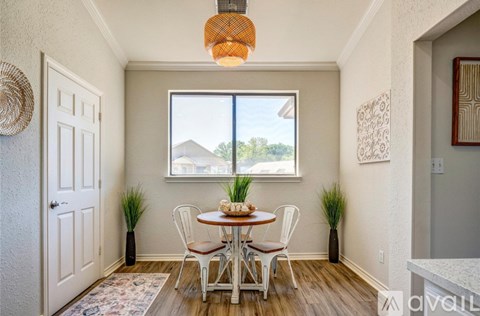 A dining room with a table set for two and a view of the outdoors.