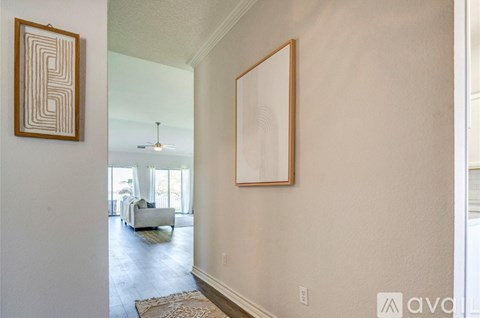 A hallway with a framed picture on the wall and a rug on the floor.