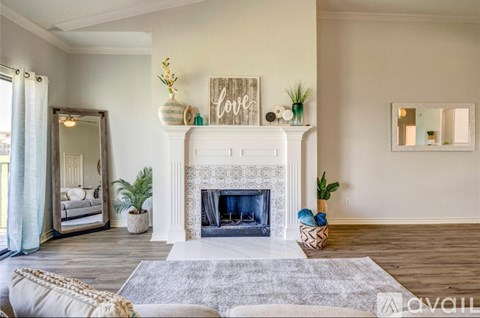 A living room with a fireplace and a mirror on the wall.