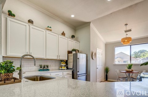A kitchen with white cabinets and a granite countertop.