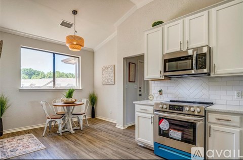 A kitchen with a table and chairs by a window.
