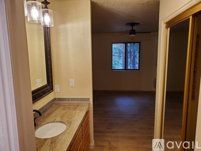 A bathroom with a sink, mirror, and a window.