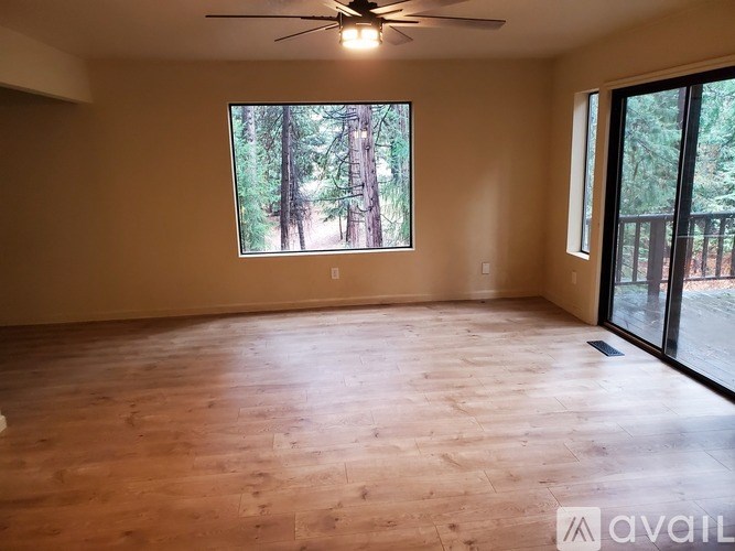 A room with wooden flooring and a ceiling fan.