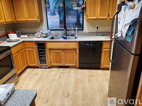 A kitchen with wooden cabinets and a black dishwasher.