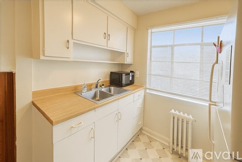 A kitchen with white cabinets and a wooden countertop.