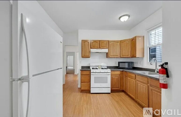 A kitchen with wooden cabinets and a white fridge.