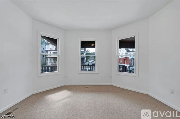 A room with two windows and a carpeted floor.
