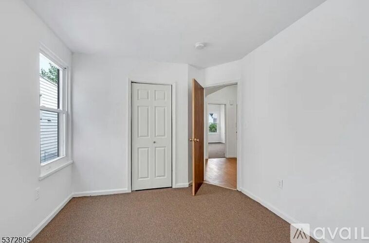 A room with a white door and a window with blinds.