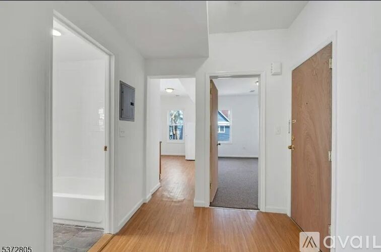 A hallway with a door on the right and a window in the distance.