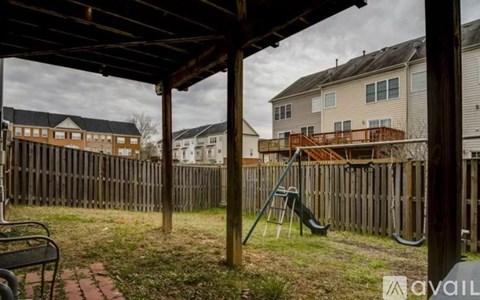 A backyard with a wooden fence and a playground.