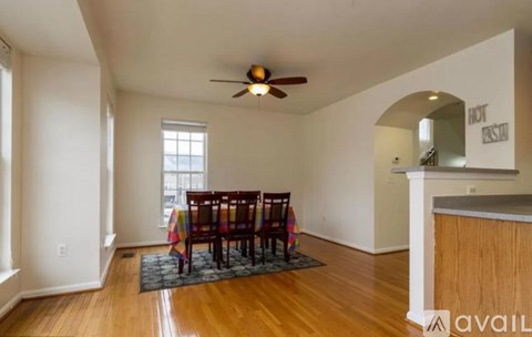 A room with a wooden floor and a ceiling fan.