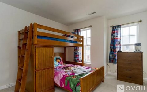A bedroom with a bunk bed and a dresser.