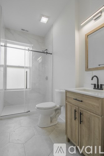 A bathroom with a toilet, sink, and mirror.