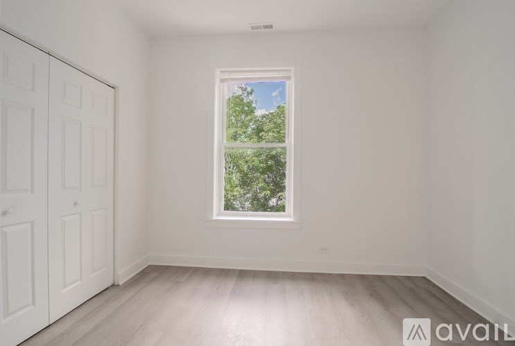A room with a window showing greenery outside.