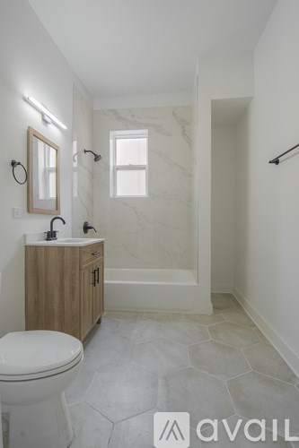 A bathroom with a toilet, sink, and mirror.