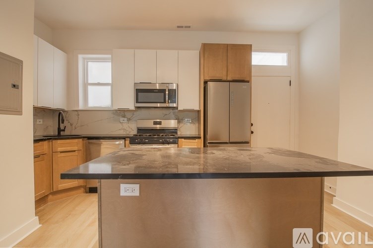 A kitchen with a black countertop and stainless steel appliances.