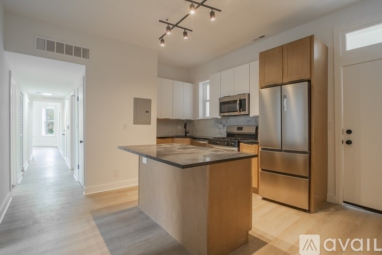 A kitchen with wooden cabinets and a stainless steel refrigerator.