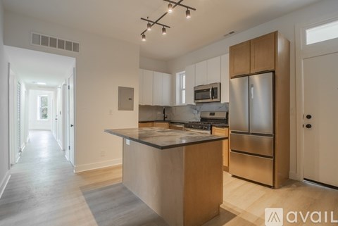 A kitchen with wooden cabinets and a stainless steel refrigerator.