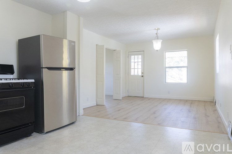 A kitchen with a black stove top oven and a stainless steel refrigerator.