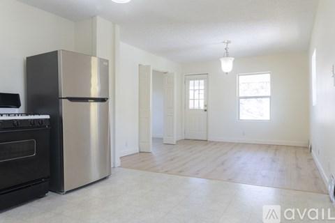 A kitchen with a black stove top oven and a stainless steel refrigerator.