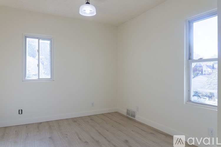 A room with a window and a wooden floor.
