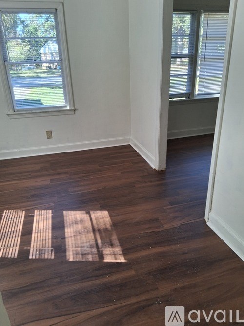 A room with a window and wooden flooring.