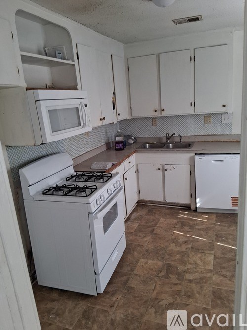 A kitchen with white appliances and cabinets.