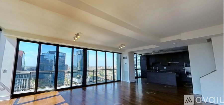 A spacious living room with a view of the cityscape outside the large windows.