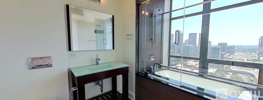 A bathroom with a large mirror and a view of the city.
