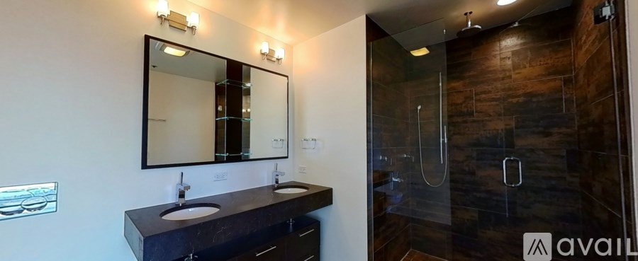 A bathroom with a dark wood wall and a glass shower stall.
