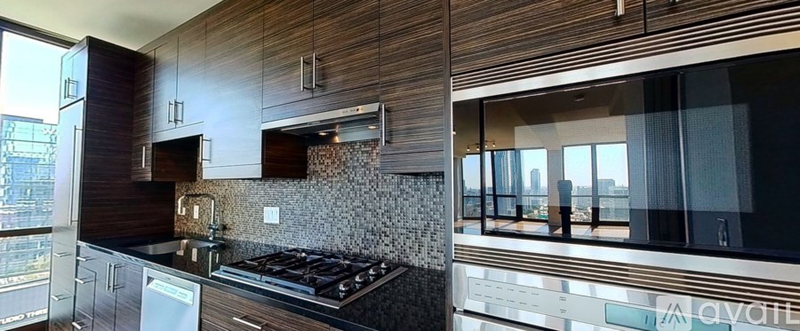 A modern kitchen with wooden cabinets and a black stove top.