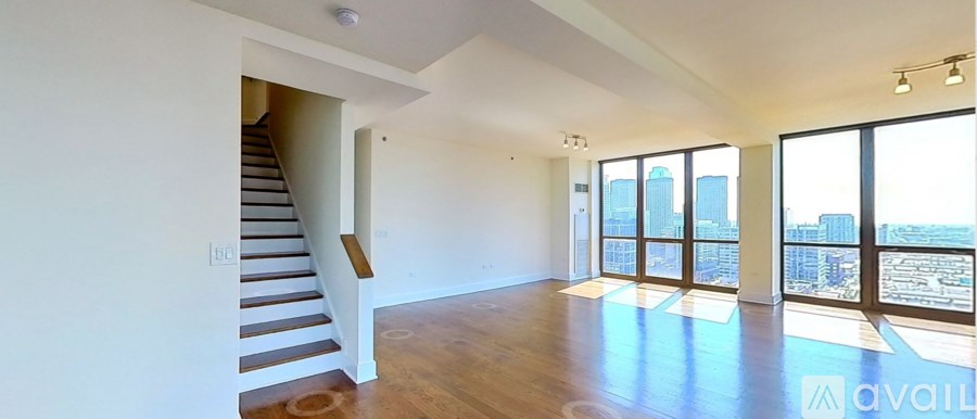 A spacious living room with a staircase leading to the upper floor.