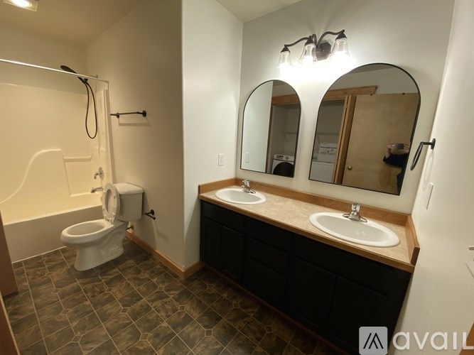 A bathroom with a toilet, sink, and mirror.