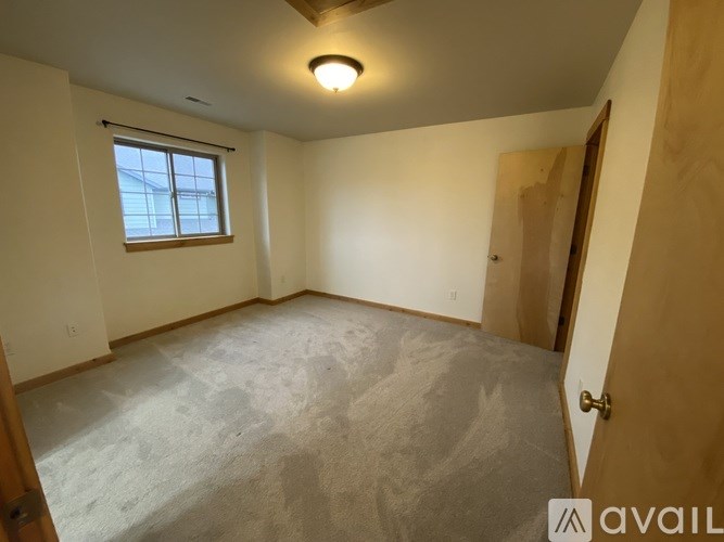 A room with a window and a door is available for rent.