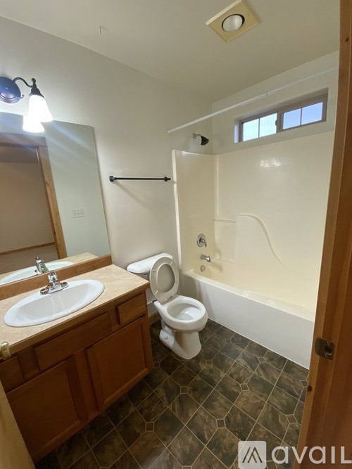 A bathroom with a toilet, sink, and bathtub.