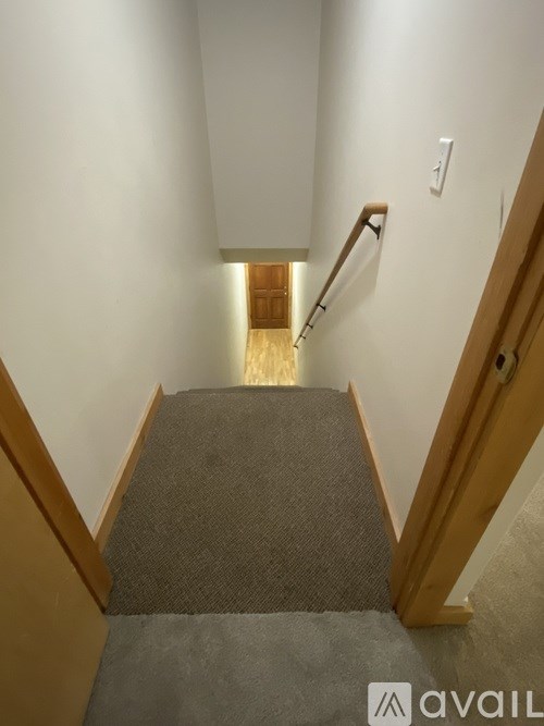 A staircase with a carpeted runner and wooden handrails.