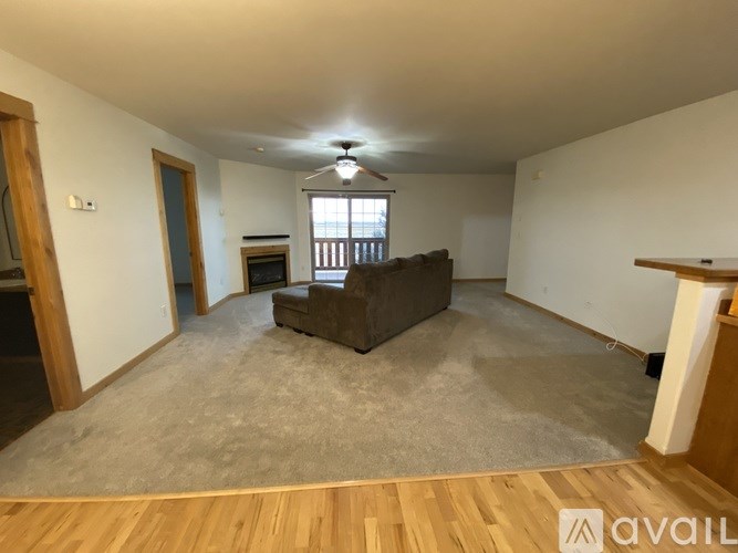 A living room with a brown sofa and a wooden floor.