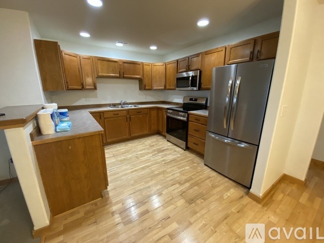 A kitchen with wooden cabinets and a refrigerator.