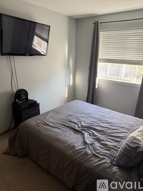A bedroom with a bed, a television, and a speaker.