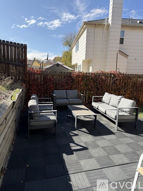 A patio with a grey tiled floor and a white sofa.