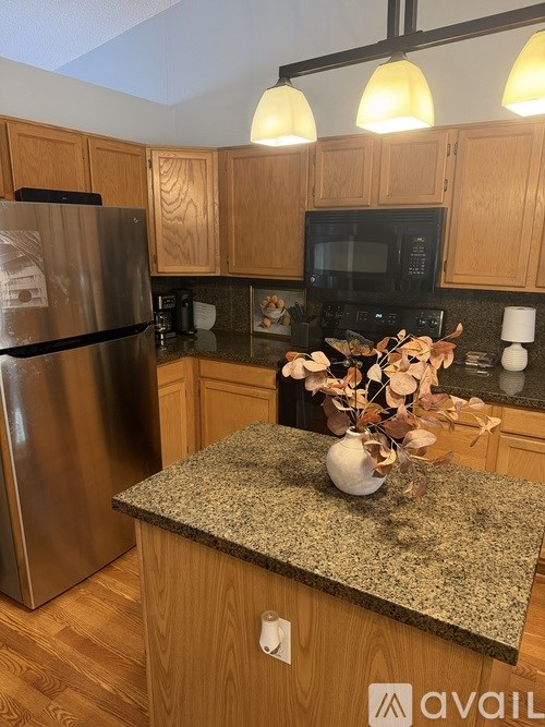 A kitchen with wooden cabinets and granite countertops.