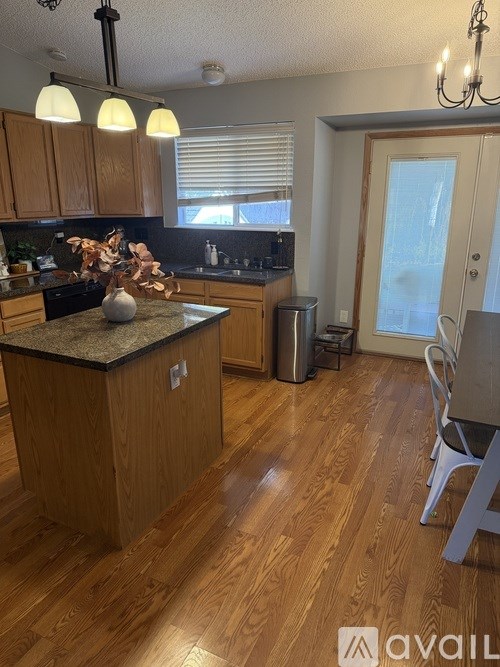 A kitchen with wooden cabinets and a granite countertop.
