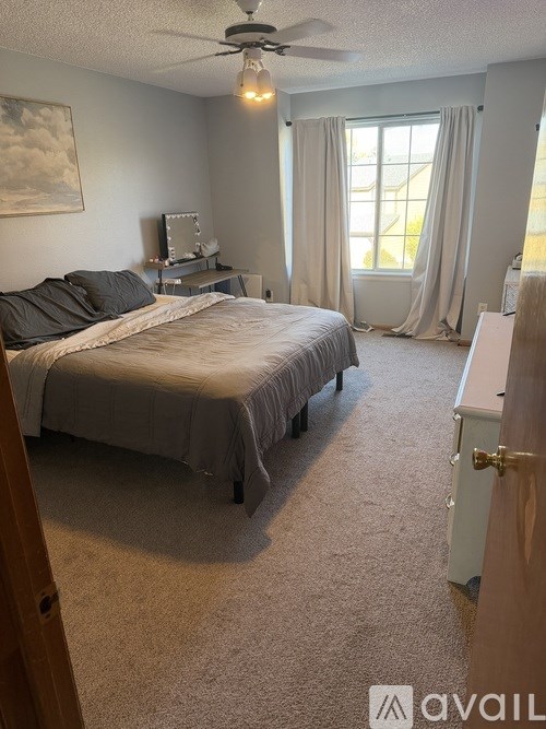 A bedroom with a bed, dresser, and window.