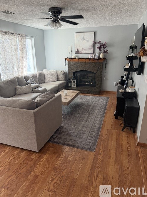 A living room with a couch, coffee table, and fireplace.